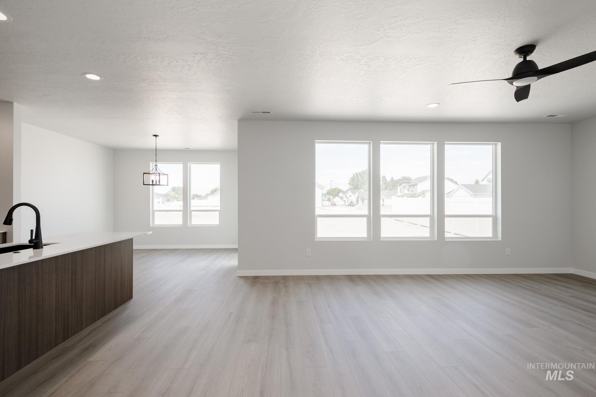 5131 Castleton Avenue Nampa, ID 83686 - Photo 19 of 25 Unfurnished living room with light wood-type flooring, a textured ceiling, ceiling fan, and recessed lighting