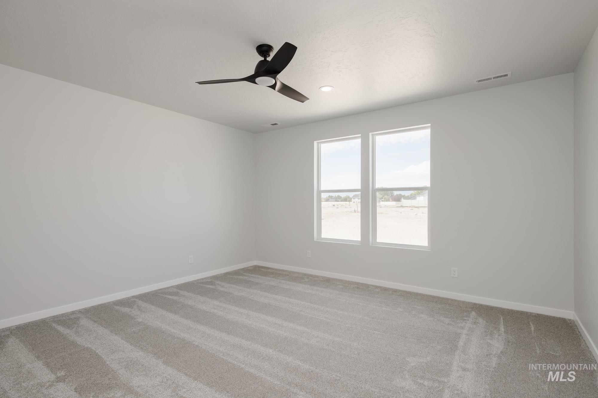 5131 Castleton Avenue Nampa, ID 83686 - Photo 21 of 25 Empty room featuring light carpet, ceiling fan, and recessed lighting