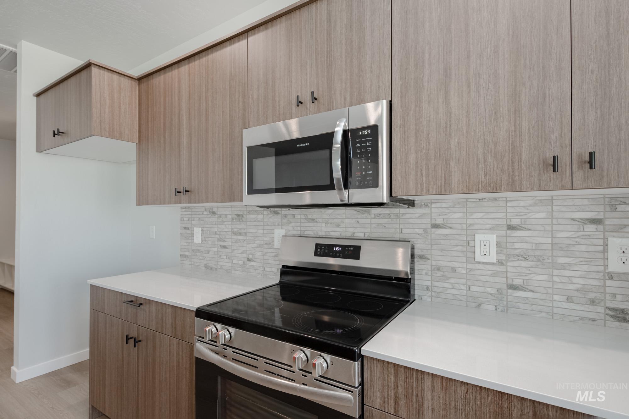 5131 Castleton Avenue Nampa, ID 83686 - Photo 6 of 25 Kitchen featuring appliances with stainless steel finishes, backsplash, light countertops, modern cabinets, and light brown cabinetry