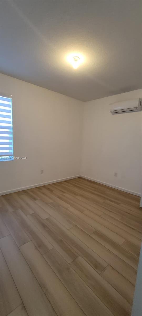 27118 Southwest 132 Ct Road Homestead, FL 33032 - Photo 6 of 9 en empty room with wooden floor and windows