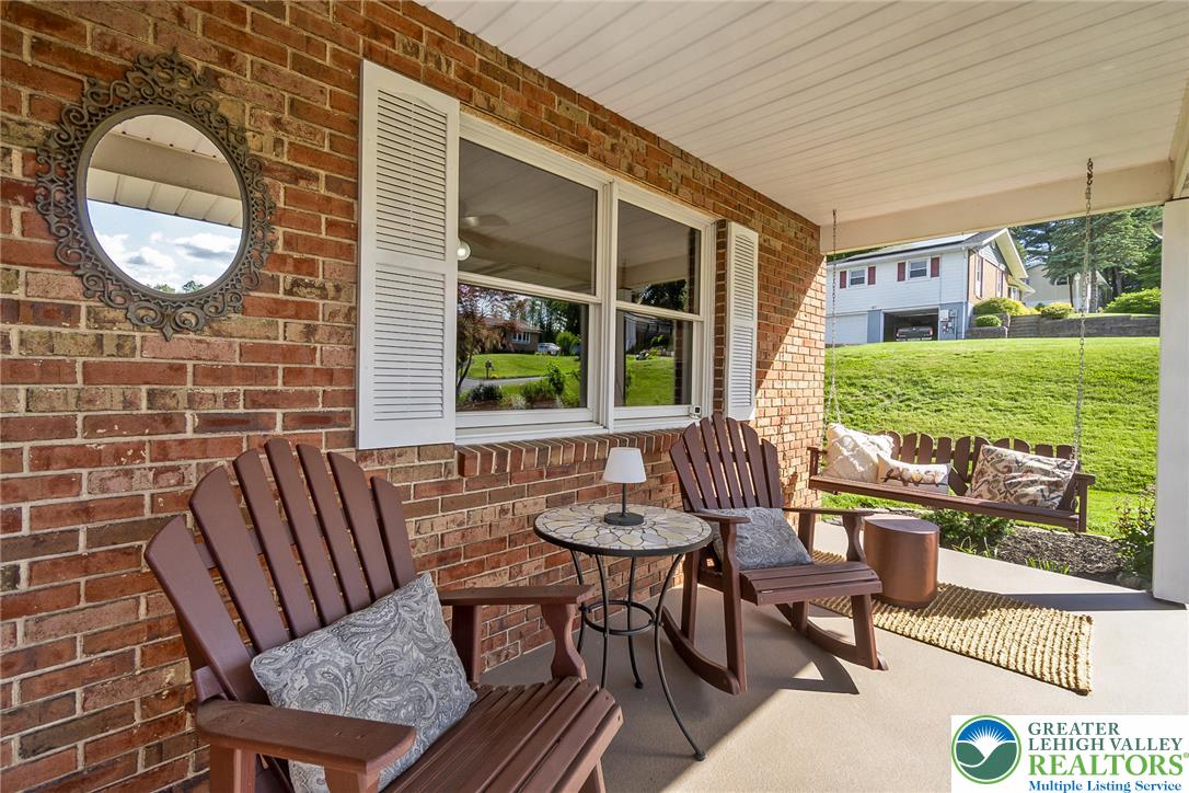 540 Briar Road Pen Argyl, PA 18072 - Photo 6 of 66 welcoming front porch with inviting seating, and lush green surroundings.