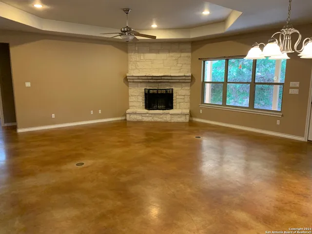 an empty room with windows and fireplace