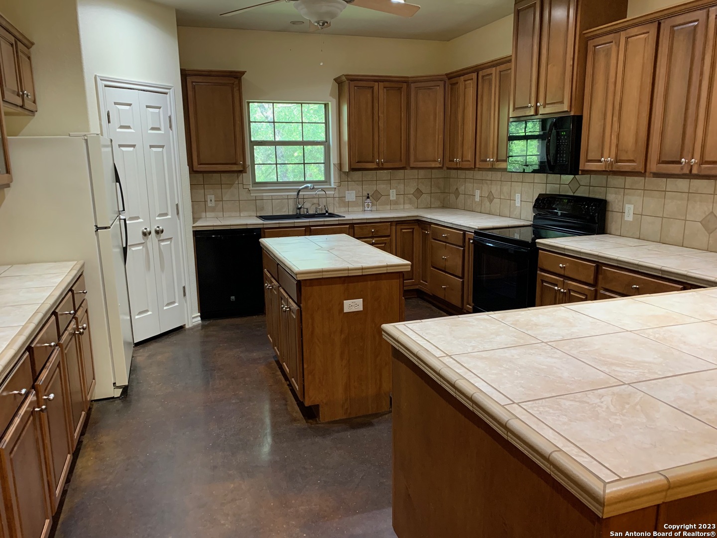 8729 Fair Oaks Parkway Fair Oaks Ranch, TX 78015 - Photo 5 of 11 a kitchen with a sink stove and refrigerator