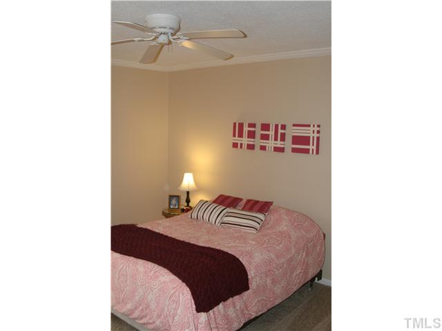 1524 Woodcroft Drive Raleigh, NC 27609 - Photo 20 of 25 a bedroom with a bed and a chandelier