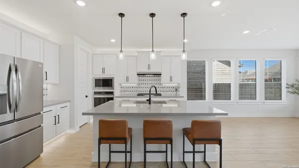 a kitchen with stainless steel appliances granite countertop a kitchen island a stove and a refrigerator