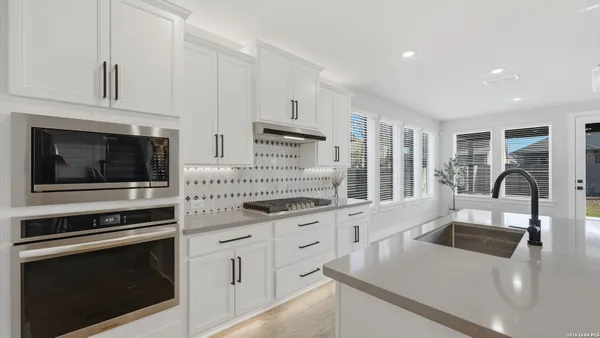 a kitchen with stainless steel appliances granite countertop a stove and white cabinets