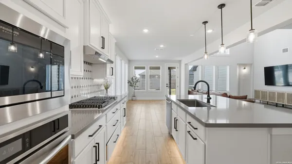 a kitchen with stainless steel appliances granite countertop a sink and a stove