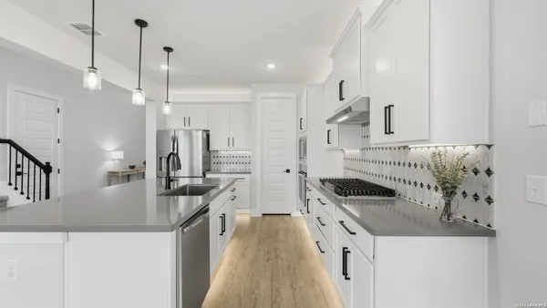 a kitchen with stainless steel appliances granite countertop a sink a stove and a refrigerator