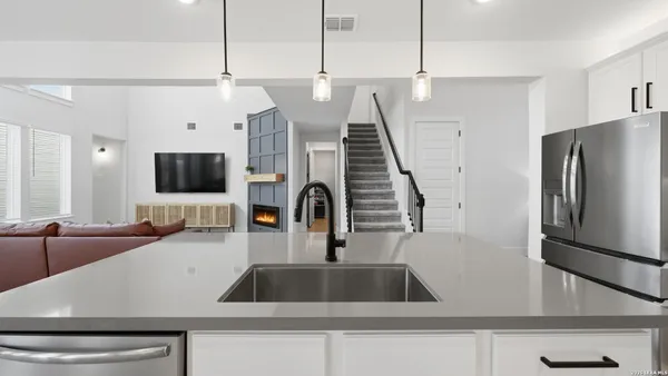 a kitchen with a sink a counter top space and stainless steel appliances