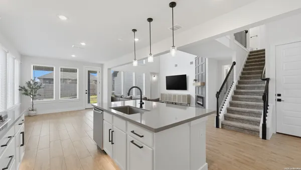a kitchen with sink stove and wooden floor