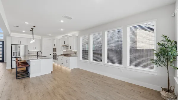 a kitchen with a refrigerator and a wooden floor