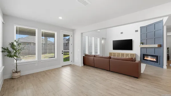 a living room with furniture a flat screen tv and a fireplace