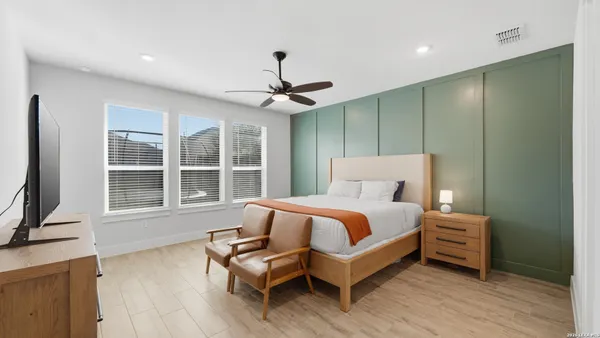 a bedroom with a bed wooden floor and window