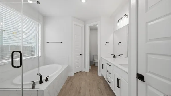 a bathroom with a tub sink and mirror