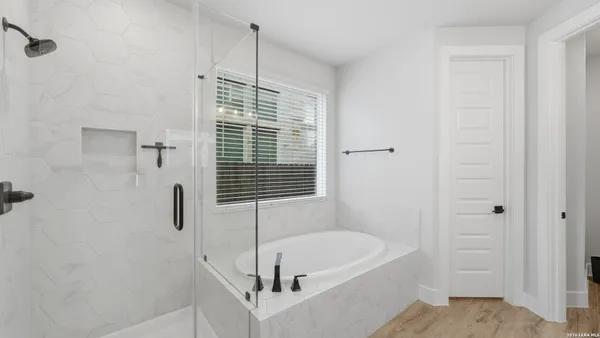 a bathroom with a tub a sink and a window