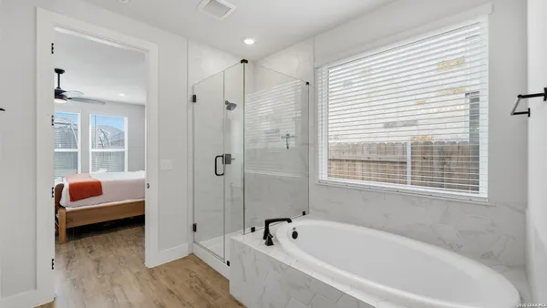 a bathroom with a tub a sink and a window