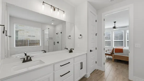 a bathroom with a double vanity sink a mirror and shower