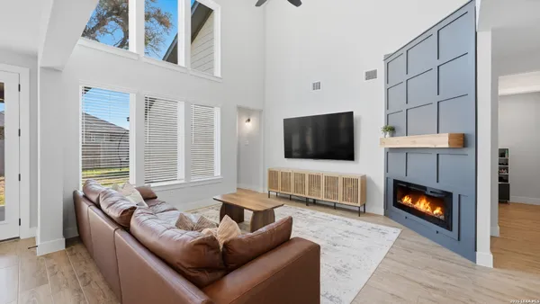 a living room with furniture a flat screen tv and a fireplace