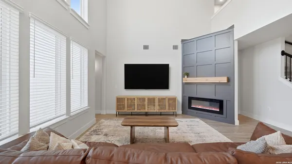 a living room with furniture a flat screen tv and a fireplace