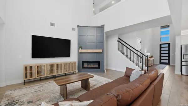 a living room with furniture a flat screen tv and a fireplace