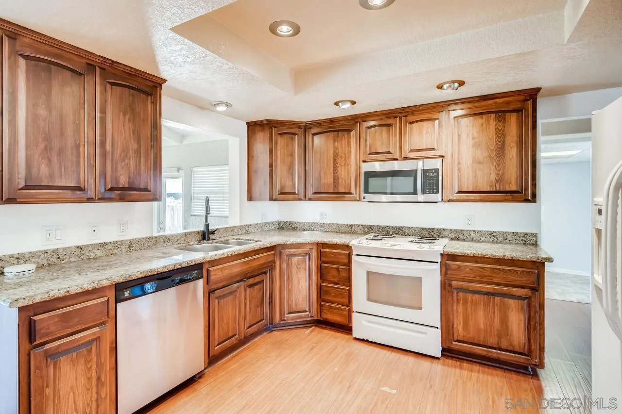 139 Landale Lane El Cajon, CA 92019 - Photo 3 of 11 a kitchen with stainless steel appliances granite countertop a sink stove and cabinets