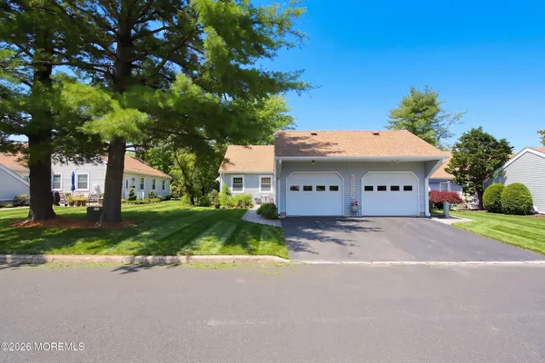 a view of a house with a yard and large tree