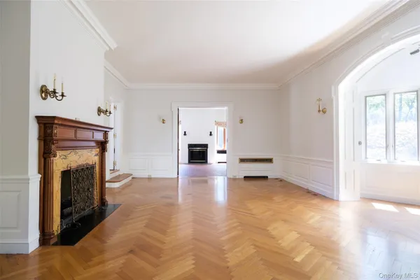a view of empty room with fireplace and wooden floor