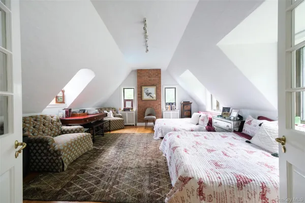 a spacious bedroom with a bed a mirror and a window