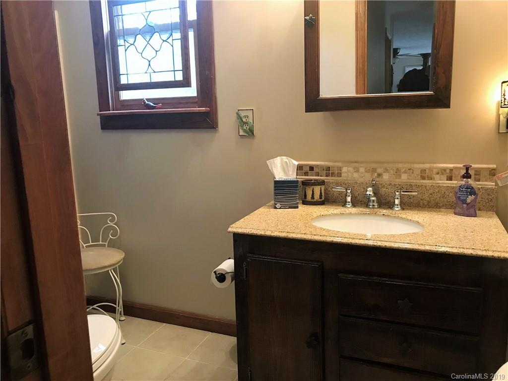 707 Phillips Gap Road Purlear, NC 28665 - Photo 18 of 27 a bathroom with a granite countertop sink and a toilet