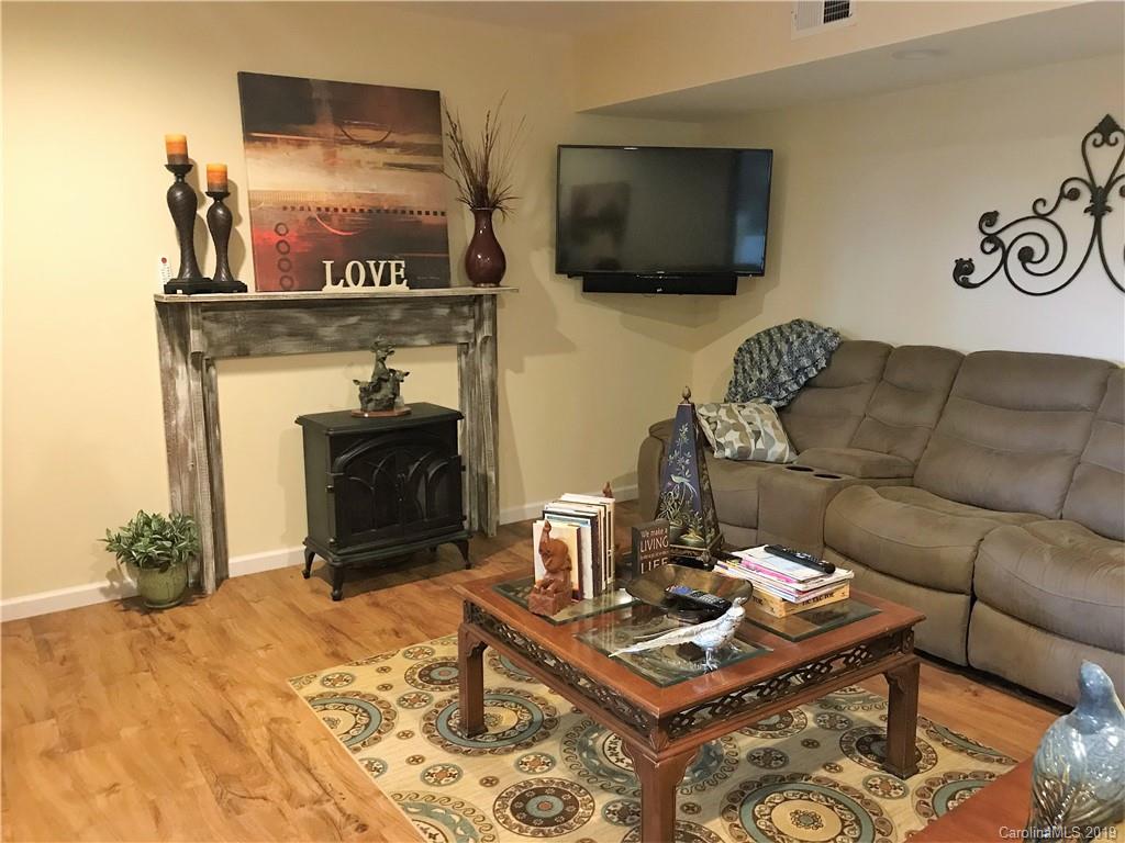 707 Phillips Gap Road Purlear, NC 28665 - Photo 25 of 27 a living room with furniture a flat screen tv and a fireplace