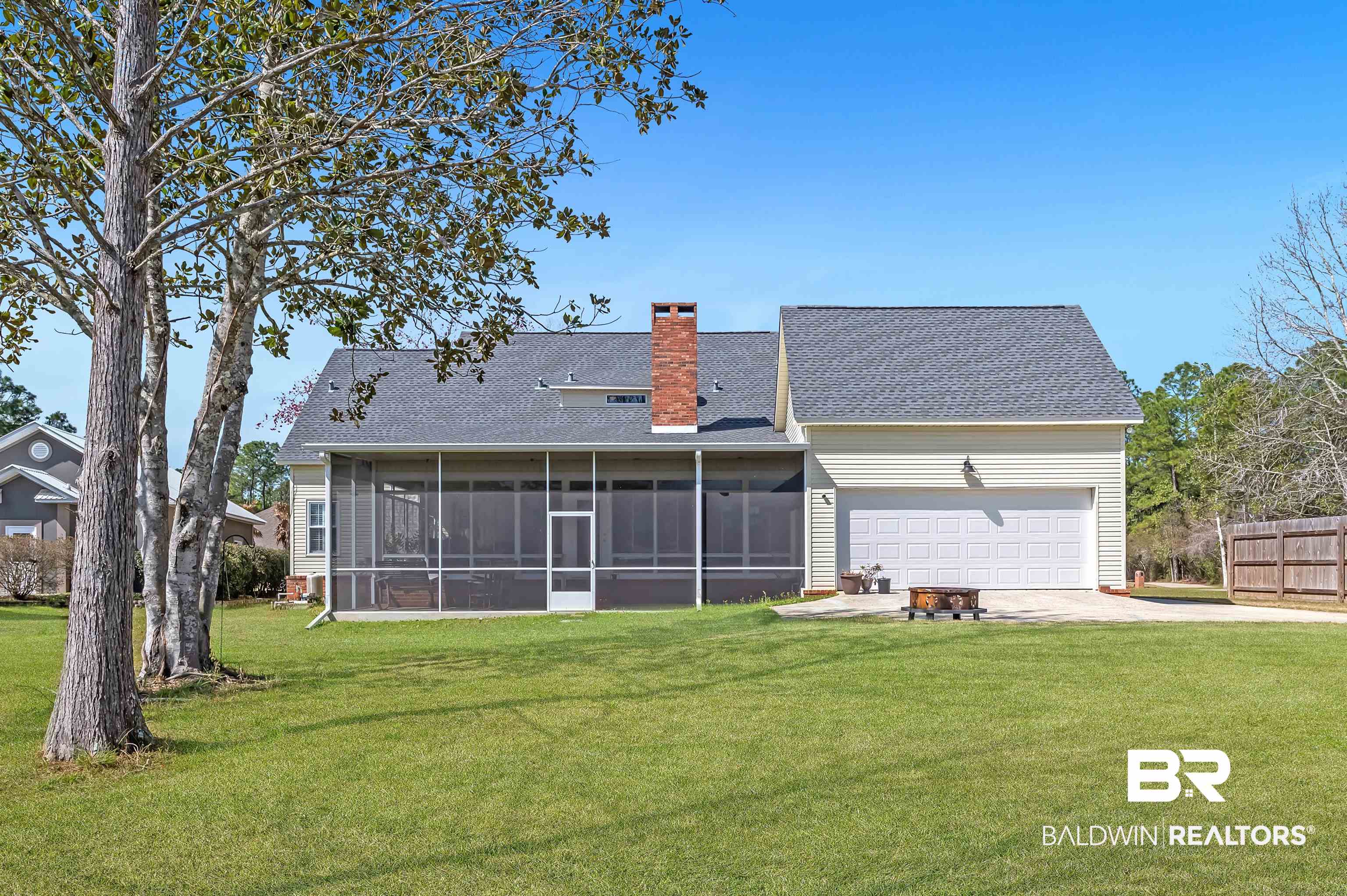 8915 Bay Point Drive Elberta, AL 36530 - Photo 73 of 74 Back of house with concrete driveway, a chimney, an attached garage, and a lawn
