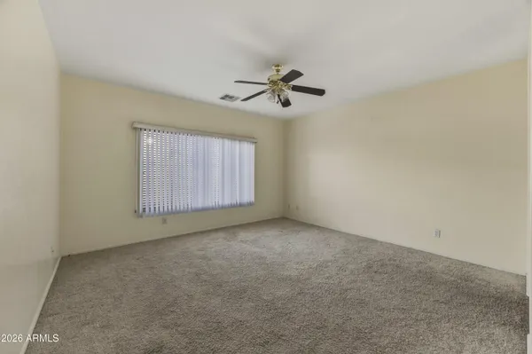 an empty room with windows and fan