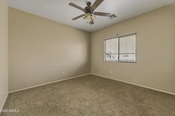 an empty room with windows and fan