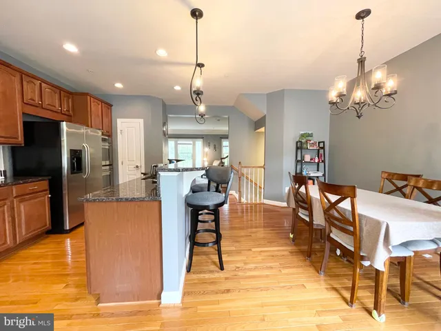a view of a dining room and livingroom with furniture wooden floor a chandelier