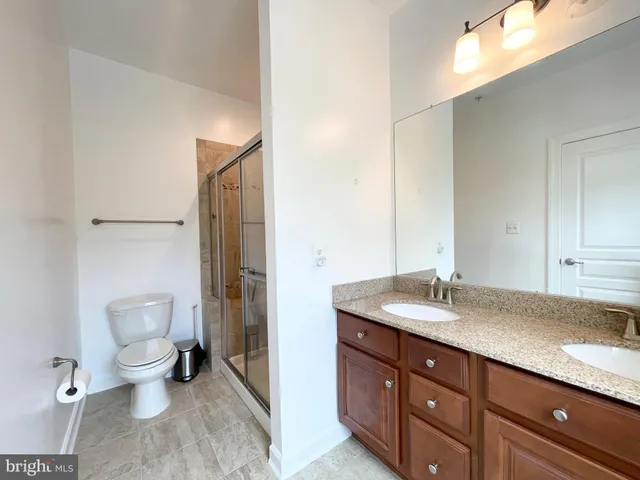 a spacious bathroom with a granite countertop sink toilet and shower