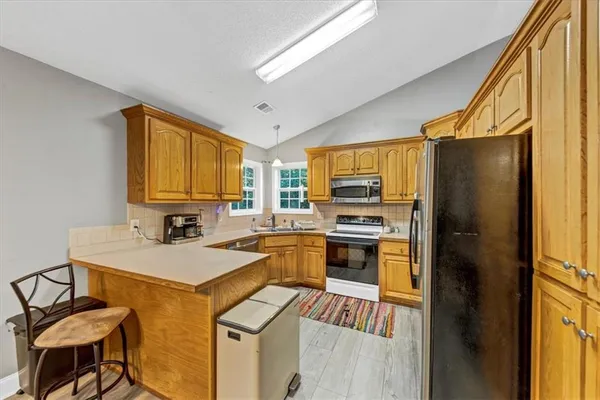 a kitchen with stainless steel appliances granite countertop a stove a sink and a microwave