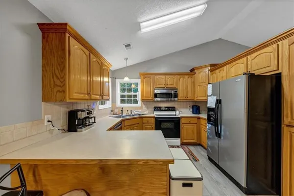 a kitchen with stainless steel appliances granite countertop a refrigerator and a stove top oven