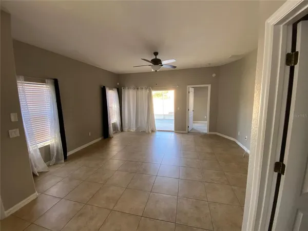 a view of a hallway with a chandelier fan and windows