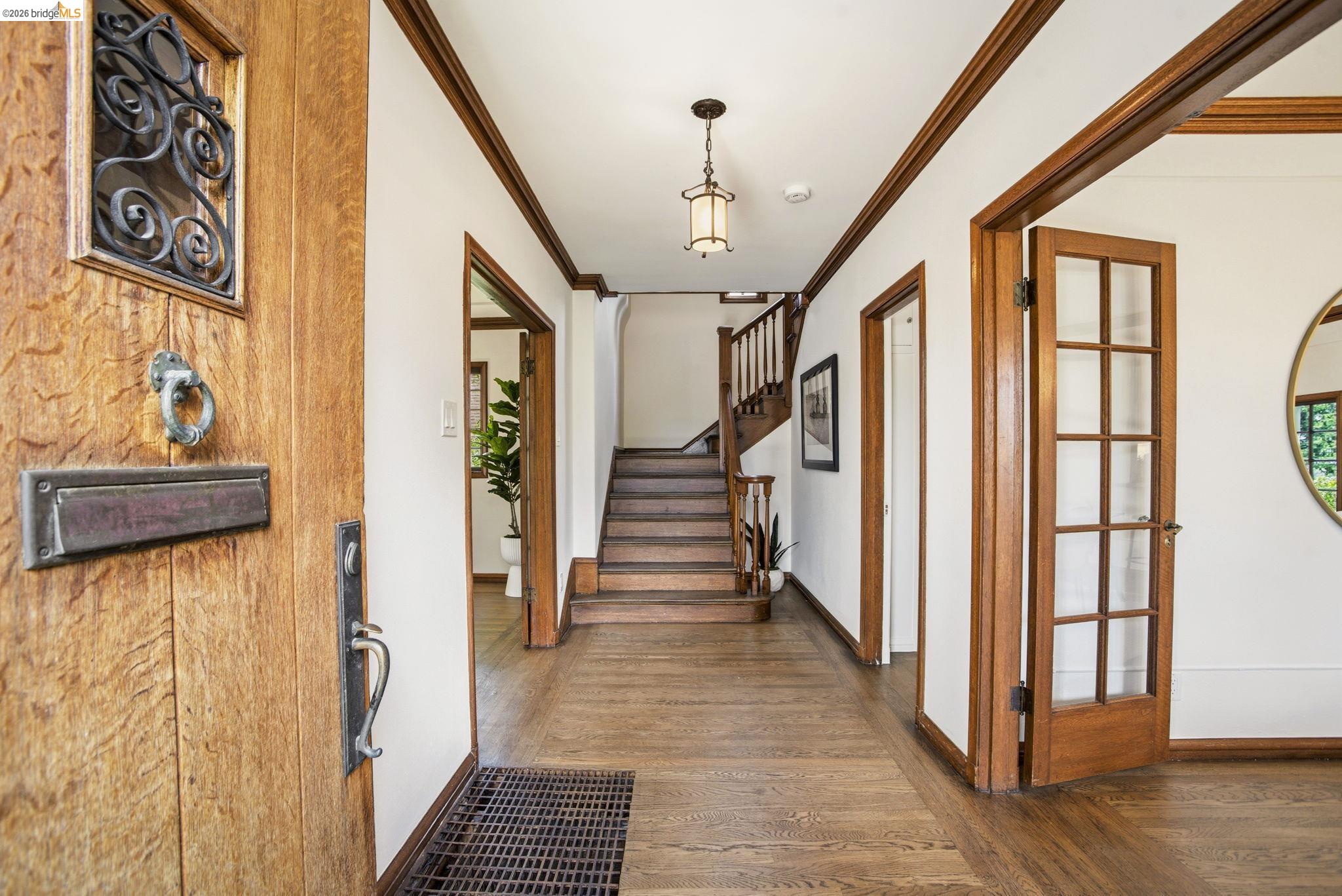 1087 Hubert Road Oakland, CA 94610 - Photo 3 of 67 Grand entry foyer featuring wood-finish flooring, extensive wood trim, and a classic lantern pendant light
