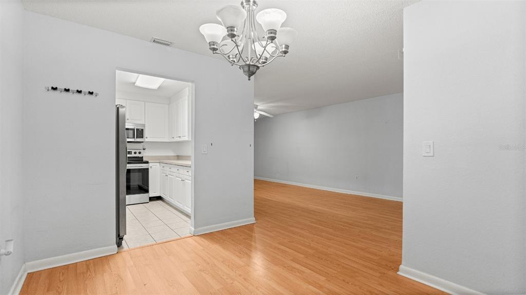 501 Southwest 75th Street, Unit B5 Gainesville, FL 32607 - Photo 8 of 38 a view of a kitchen with a white cabinet and a chandelier