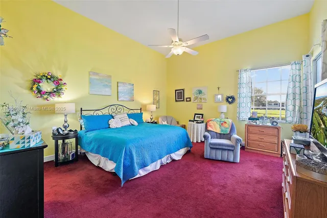 a spacious bedroom with a bed table flowerpot and a couch