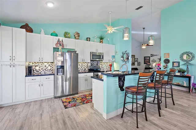 a kitchen with stainless steel appliances kitchen island granite countertop a refrigerator and microwave