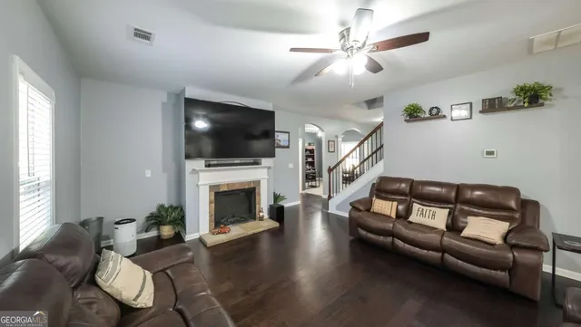 a living room with furniture a flat screen tv and a fireplace