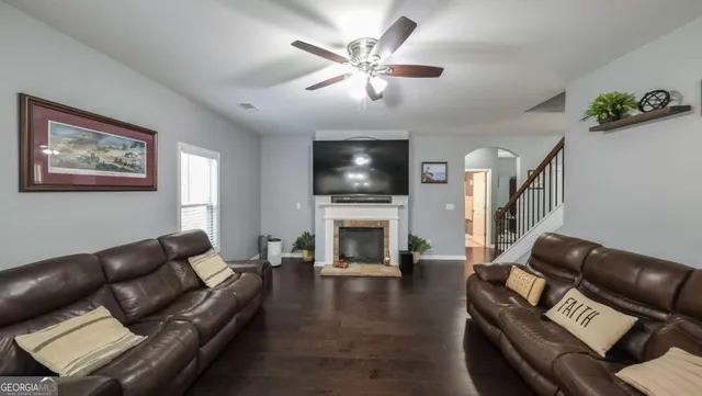 a living room with furniture a fireplace and a flat screen tv