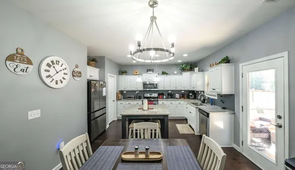 a open dining room with stainless steel appliances kitchen island granite countertop furniture a dining table and chairs