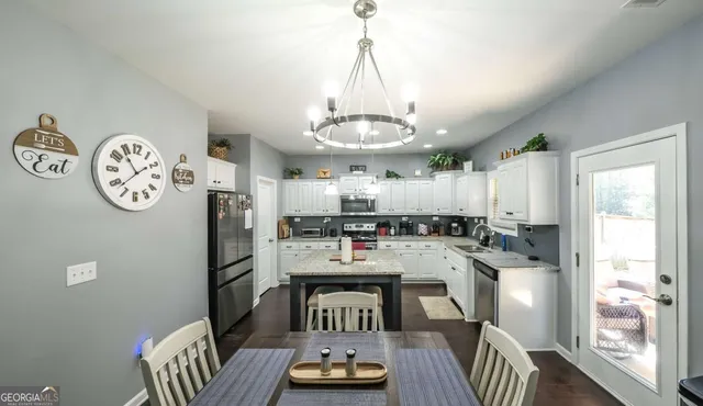 a open dining room with stainless steel appliances kitchen island granite countertop furniture a dining table and chairs