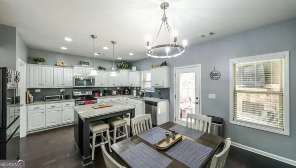 a kitchen with stainless steel appliances granite countertop a sink dishwasher stove refrigerator and cabinets