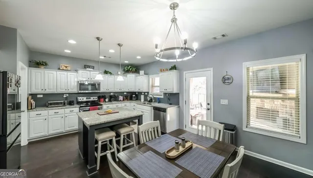 a kitchen with stainless steel appliances granite countertop a sink dishwasher stove refrigerator and cabinets