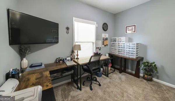 a view of a livingroom with workspace and a window