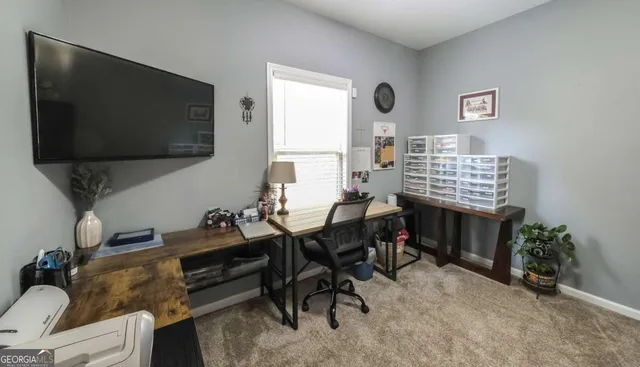 a view of a livingroom with workspace and a window